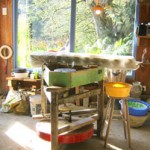 Interior of the Puketai Pottery studio with pottery wheel and shelves