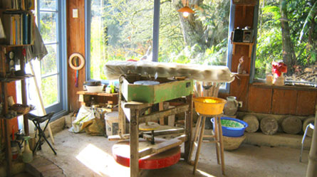 Interior of the Puketai Pottery studio with pottery wheel and shelves